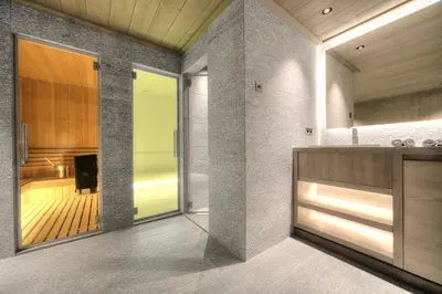 a bathroom with a large glass door and a sink at Chalet Crystal in Megève