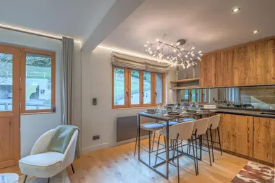 a kitchen with a table with chairs and a dining room at Duplex Veyra - Welkeys in Megève