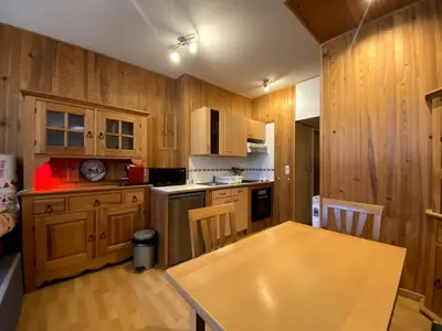 a kitchen with wooden cabinets and a wooden table with a wooden table at Charmant studio Chamonix in Chamonix-Mont-Blanc