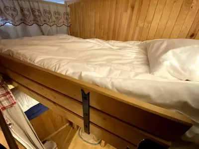 a bed in a room with a wooden wall at Charmant studio Chamonix in Chamonix-Mont-Blanc