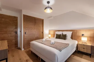 a bedroom with a large white bed and two lamps at Alpine Bliss - Sources, Ski in Saint-Gervais-les-Bains