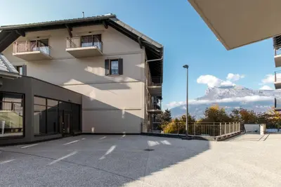 a large white building with a mountain in the background at Alpine Bliss - Sources, Ski in Saint-Gervais-les-Bains
