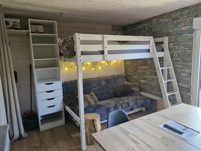 a room with a bunk bed and a table at Studio rénové pour 4 au pied de la piste de luge - FR-1-836-13 in Arâches-la-Frasse