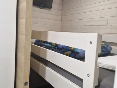 a bunk bed in a small room with wooden walls at Studio rénové pour 4 au pied de la piste de luge - FR-1-836-13 in Arâches-la-Frasse