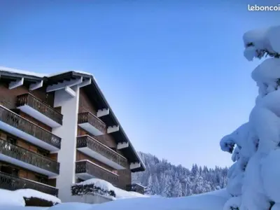 a building covered in snow with snow covered trees at Studio rénové pour 4 au pied de la piste de luge - FR-1-836-13 in Arâches-la-Frasse