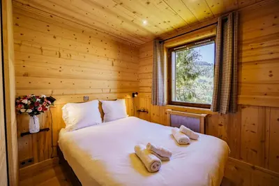 a bedroom with a bed in a wooden room at Le Majestic - Proche pistes et centre ville in Megève