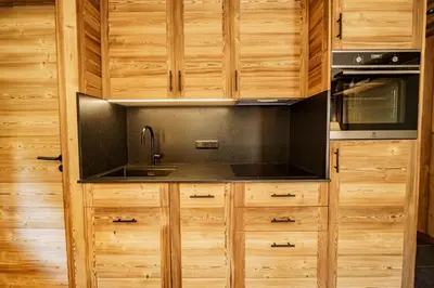 a kitchen with wooden cabinets and a sink at Le Majestic - Proche pistes et centre ville in Megève