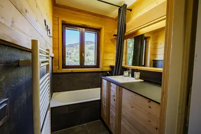 a bathroom with a tub and a sink and a bath tub at Le Majestic - Proche pistes et centre ville in Megève