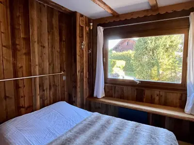 a bedroom with a window and a bed in a room at Cozy apartment chalet atmosphere in Megève