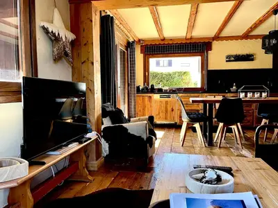 a living room with a couch and a table at Cozy apartment chalet atmosphere in Megève
