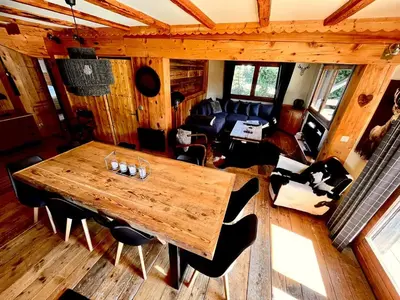 a wooden table and chairs in a living room at Cozy apartment chalet atmosphere in Megève