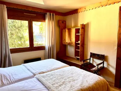 a bedroom with a bed and a window at Cozy apartment chalet atmosphere in Megève