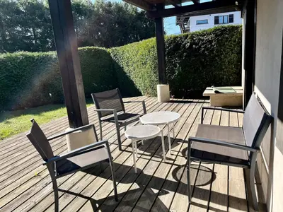 a group of chairs and a table on a deck at Cozy apartment chalet atmosphere in Megève