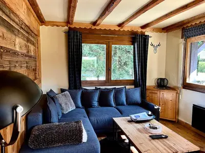 a living room with a blue couch and a wooden table at Cozy apartment chalet atmosphere in Megève