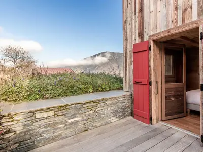 a barn with a red door on a deck at Chalet rénové pour 10 pers., St-Gervais, balcon, parking - FR-1-663-54 in Saint-Gervais-les-Bains