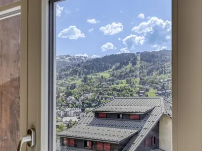 a kitchen with a counter and two green bar stools at Duplex 4 pièces, 3 chambres, 6 personnes, proche centre, parking, wifi - FR-1-663-52 in Saint-Gervais-les-Bains