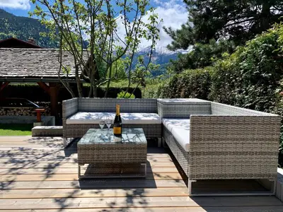 a bottle of wine sits on a table on a patio at Alpen Lounge in Servoz