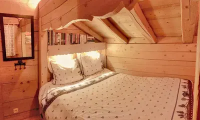 a bedroom with a bed in a wooden cabin at Alpen Lounge in Servoz