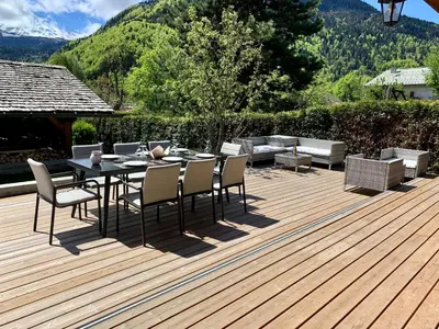 a wooden deck with a table and chairs on it at Alpen Lounge in Servoz