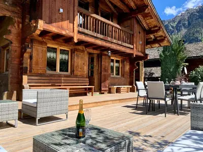 a house with a deck with a table and chairs at Alpen Lounge in Servoz