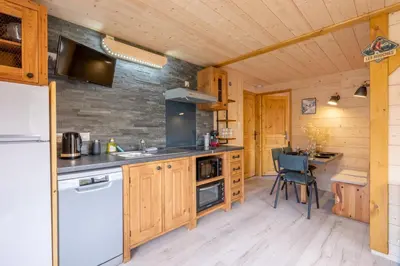 a kitchen with wooden cabinets and a counter top at Apartment at the foot of the slopes with view in Les Houches