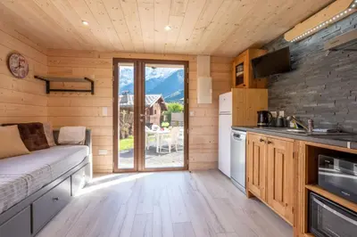 a kitchen with a couch in a tiny house at Apartment at the foot of the slopes with view in Les Houches