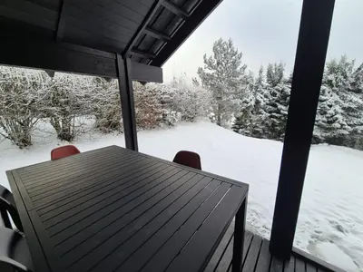 a snow covered field with cars parked in front of a house at Chalet refait à neuf avec parking privé - 4 pers. - FR-1-836-38 in Arâches-la-Frasse