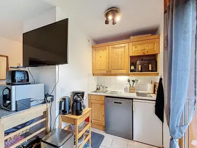 a small kitchen with wooden cabinets and a refrigerator at Charmant 2 Pièces proche piste à Combloux - FR-1-560-169 in Combloux
