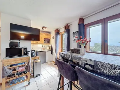 a kitchen with a bar with chairs and a counter top at Charmant 2 Pièces proche piste à Combloux - FR-1-560-169 in Combloux