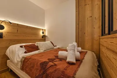 a bedroom with a bed with towels on it at Argy - Apart Moderne - Vue MtBlanc - 5mn Pistes - Parking in Chamonix-Mont-Blanc