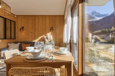 a table in a room with a view of the mountains at Argy - Apart Moderne - Vue MtBlanc - 5mn Pistes - Parking in Chamonix-Mont-Blanc