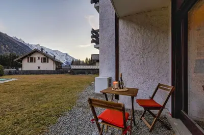 a table and two chairs sitting outside of a building at Argy - Apart Moderne - Vue MtBlanc - 5mn Pistes - Parking in Chamonix-Mont-Blanc