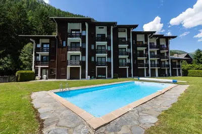 a large building with a swimming pool in front of it at Argy - Apart Moderne - Vue MtBlanc - 5mn Pistes - Parking in Chamonix-Mont-Blanc