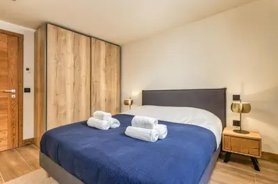 a bedroom with a large bed with towels on it at Wim in Les Houches