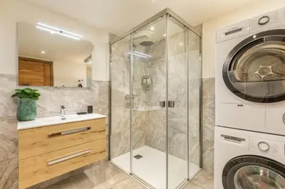 a bathroom with a shower and a washing machine at Wim in Les Houches