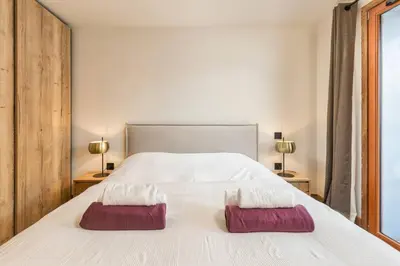 a bedroom with a white bed with two pillows on it at Wim in Les Houches