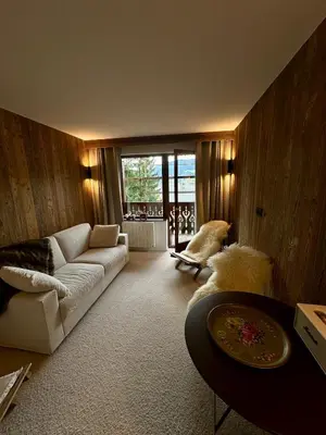 a living room with a white couch and a table at Cocon de charme à Megève, confort et vue in Megève