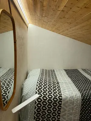 a small room with a bed and a wooden ceiling at 2 bedroom apartment, in Saint-Gervais-les-Bains