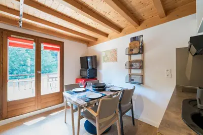 a dining room with a table and chairs and a window at 2 bedroom apartment, in Saint-Gervais-les-Bains