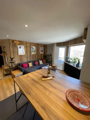 a living room with a table and a couch at BlackWood Lodge in Saint-Gervais-les-Bains