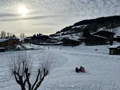two people sitting in the snow in a village at Sunny 2 Bedrooms Apartment for 4 in Megève Jaillet, right on the Ski Slopes in Megève