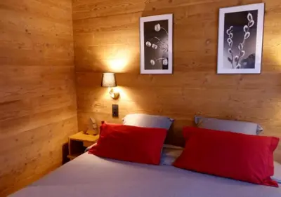 a bedroom with a bed with two red pillows at Chalet Maloya, confortable appartement proche remontées et village, prestations premium in Saint-Gervais-les-Bains