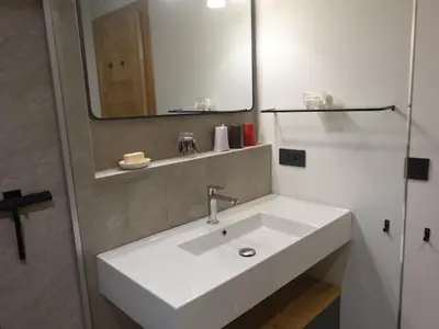 a bathroom with a white sink and a mirror at Chalet Maloya, confortable appartement proche remontées et village, prestations premium in Saint-Gervais-les-Bains