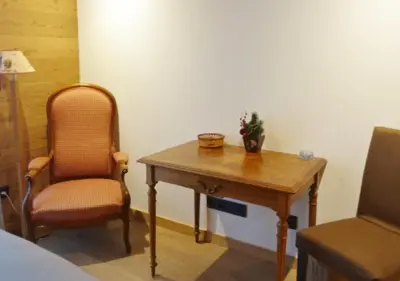 a room with a wooden table and a chair at Chalet Maloya, confortable appartement proche remontées et village, prestations premium in Saint-Gervais-les-Bains