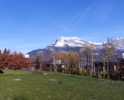 a snow covered mountain in the distance with a field at Chalet Maloya, confortable appartement proche remontées et village, prestations premium in Saint-Gervais-les-Bains