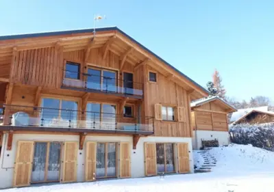 a large wooden house in the snow at Chalet Maloya, confortable appartement proche remontées et village, prestations premium in Saint-Gervais-les-Bains