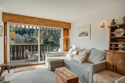 a living room with a couch and a large window at Apartment Mika , Alpes Travel, Slope side location, Central Chamonix, Sleeps 4 6 in Chamonix-Mont-Blanc