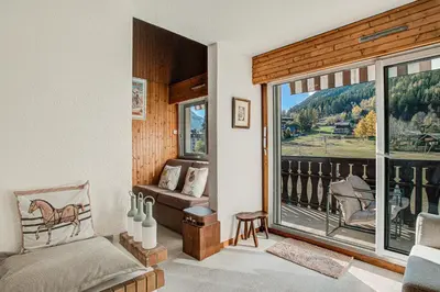 a bedroom with a bed and a large window at Apartment Mika , Alpes Travel, Slope side location, Central Chamonix, Sleeps 4 6 in Chamonix-Mont-Blanc