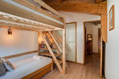 a bedroom with two bunk beds and a ladder at Apartment Mika , Alpes Travel, Slope side location, Central Chamonix, Sleeps 4 6 in Chamonix-Mont-Blanc