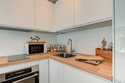a white kitchen with a sink and a microwave at Apartment Mika , Alpes Travel, Slope side location, Central Chamonix, Sleeps 4 6 in Chamonix-Mont-Blanc